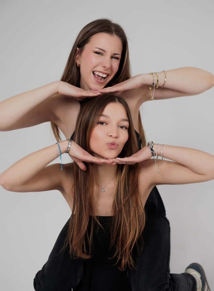 Angie and Eva stacked, each resting her chin on her hands